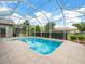 Relax and unwind by the refreshing pool, complete with a screened enclosure and lush landscaping at 9032 Cypress Glen Ct, Weeki Wachee, FL 34613