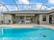 Enjoy a beautifully designed pool with a screened enclosure, alongside a covered patio and outdoor kitchen area at 9032 Cypress Glen Ct, Weeki Wachee, FL 34613