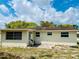 Back exterior featuring neutral siding, windows, and small patio, offering outdoor space at 9136 Mark Twain Ln, Port Richey, FL 34668