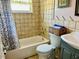Compact tiled bathroom featuring a shower-tub combo and unique decor for a functional space at 9136 Mark Twain Ln, Port Richey, FL 34668