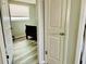 Cozy bedroom with wood-look floors, neutral walls, and a comfortable bed near the doorway at 9136 Mark Twain Ln, Port Richey, FL 34668