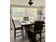 Dining area featuring a large table, comfortable chairs, wood-look floors, and a large window at 9136 Mark Twain Ln, Port Richey, FL 34668