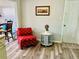 Cozy entryway featuring a red chair and a table near the front door, with wood-look floors at 9136 Mark Twain Ln, Port Richey, FL 34668
