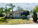 Charming single-story home with well-maintained lawn, palm trees, and inviting front entrance at 9136 Mark Twain Ln, Port Richey, FL 34668