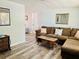Well-lit living room featuring comfortable seating, wood-look floors, and plenty of space at 9136 Mark Twain Ln, Port Richey, FL 34668