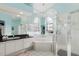 Bright bathroom featuring dual sinks, a soaking tub, and a glass-enclosed shower for a spa-like experience at 9301 Tournament Dr, Hudson, FL 34667