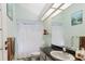 Bathroom featuring a shower with curtain, toilet, and sink with dark countertop and large mirror at 9301 Tournament Dr, Hudson, FL 34667