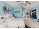 Bright bedroom with blue walls, unique white bed, tile floors, and a separate vanity area at 9301 Tournament Dr, Hudson, FL 34667