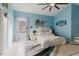 Bright bedroom featuring blue walls, a unique white bed, decorative accents, and tile flooring at 9301 Tournament Dr, Hudson, FL 34667