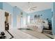 Bright bedroom with blue walls, a unique white bed, tile floors, and ample natural light through the windows at 9301 Tournament Dr, Hudson, FL 34667