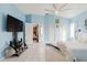 Bright bedroom with blue walls, tile flooring, large bed, and a entertainment area with TV at 9301 Tournament Dr, Hudson, FL 34667