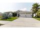Lovely front view of the home, including a 3-car garage and a well-manicured lawn at 9301 Tournament Dr, Hudson, FL 34667