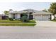 A lovely front view of this home that includes the well-manicured lawn and a three-car garage at 9301 Tournament Dr, Hudson, FL 34667