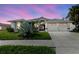 Beautiful home featuring a two-car garage, well-manicured lawn, and gorgeous front yard landscaping at 9301 Tournament Dr, Hudson, FL 34667