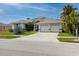 Beautiful home featuring a two-car garage, well-manicured lawn, and gorgeous front yard landscaping at 9301 Tournament Dr, Hudson, FL 34667