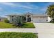 Beautiful home featuring a two-car garage, well-manicured lawn, and gorgeous front yard landscaping at 9301 Tournament Dr, Hudson, FL 34667