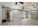 Tiled garage with refrigerator, overhead lighting, and ample room for storage and vehicle parking at 9301 Tournament Dr, Hudson, FL 34667
