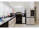 Kitchen features stainless microwave, black appliances, white cabinets and black countertop at 9301 Tournament Dr, Hudson, FL 34667