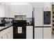 Kitchen features stainless microwave, black appliances, white cabinets and black countertop at 9301 Tournament Dr, Hudson, FL 34667