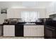 Kitchen features stainless appliances, white cabinets, black countertop, and tile flooring at 9301 Tournament Dr, Hudson, FL 34667