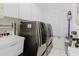 Well-equipped laundry room featuring modern washer and dryer units, storage, and a utility sink for convenience at 9301 Tournament Dr, Hudson, FL 34667
