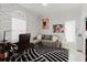 A home office with a gray couch, black and white rug, and unique wall decor at 9301 Tournament Dr, Hudson, FL 34667