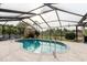 A screened-in pool with stone tiling, with natural sunlight in the background at 9301 Tournament Dr, Hudson, FL 34667