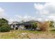 View of the pool behind the home, enclosed with a screen and surrounded by the yard at 9301 Tournament Dr, Hudson, FL 34667