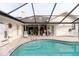 Screened in pool features stone tiling and access to outdoor entertainment space at 9301 Tournament Dr, Hudson, FL 34667