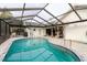 The outdoor pool features a screen enclosure and tile surround at 9301 Tournament Dr, Hudson, FL 34667