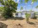 View of home exterior shows spacious yard and the home's neutral color palette at 9316 Whitman Ln, Port Richey, FL 34668