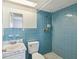 Bright blue tiled bathroom with sink, toilet, and shower at 9316 Whitman Ln, Port Richey, FL 34668