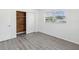 Bright bedroom features stylish gray flooring, a closet with wooden paneling, and natural light from the window at 9316 Whitman Ln, Port Richey, FL 34668