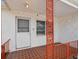 Covered front porch with tiled floor, screen door and decorative column and railing at 9316 Whitman Ln, Port Richey, FL 34668