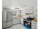 Well-lit kitchen featuring stainless steel appliances, white cabinetry, and a window above the sink at 9316 Whitman Ln, Port Richey, FL 34668