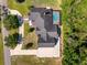 Aerial view featuring the layout of the home with screened pool and surrounding greenery at 10110 Weeks Dr, Brooksville, FL 34601
