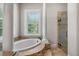 Bathroom featuring a soaking tub with tile surround and a walk-in shower at 10110 Weeks Dr, Brooksville, FL 34601