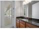 Bathroom vanity with wood cabinetry, granite countertop, single sink, and view to patio at 10110 Weeks Dr, Brooksville, FL 34601
