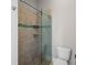 Shower enclosure with decorative tile accents, glass door, and built-in shelving at 10110 Weeks Dr, Brooksville, FL 34601