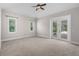 Bright bedroom with neutral carpet, ceiling fan, and french doors to screened patio at 10110 Weeks Dr, Brooksville, FL 34601