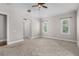 Neutral bedroom with carpet, fan, and two windows for natural light at 10110 Weeks Dr, Brooksville, FL 34601
