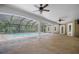 Covered patio with pool, pavers, white pillars, ceiling fans, and view of trees at 10110 Weeks Dr, Brooksville, FL 34601