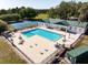 Inviting community pool area with lounge chairs, tables, and an adjacent tennis court, perfect for recreation at 10110 Weeks Dr, Brooksville, FL 34601
