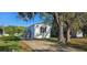 Charming white single-story home with a concrete driveway and mature trees at 11304 Altoona Ave, New Port Richey, FL 34654