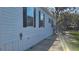 Side view of a single-story house with white siding and black shutters, showcasing its simple elegance at 11304 Altoona Ave, New Port Richey, FL 34654
