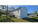 A bright exterior of a manufactured home, featuring vinyl siding, an AC unit and a wooden staircase at 11304 Altoona Ave, New Port Richey, FL 34654