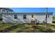 White manufactured home exterior with rear door, stairs, and landscaped yard, offering comfortable outdoor living at 11304 Altoona Ave, New Port Richey, FL 34654