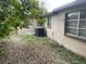 The backyard features a central air unit, some foliage, and a window at 11515 Meredith Ln, Port Richey, FL 34668