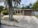 Charming single-story home featuring a stone-accented garage and arched entryway at 11515 Meredith Ln, Port Richey, FL 34668