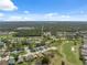 Sprawling aerial view of a residential area featuring golf courses and tree-lined streets at 11631 Wayside Willow Ct, Hudson, FL 34667